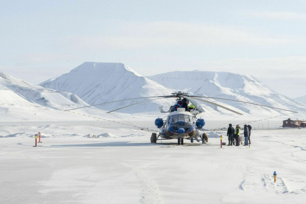 Det russiske helikopteret står klart på Svalbard Lufthavn. Russiske teknikere forsikrer seg om at alt er i orden.