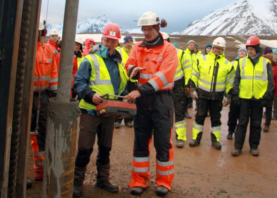 Jan Tore Sanner (H) sørget for at den første pælen ble boret den siste halvmeteren ned i bakken. I bakgrunnen følger ansatte i Veidekke Arctic og Kartverket med på den symbolske handlingen.