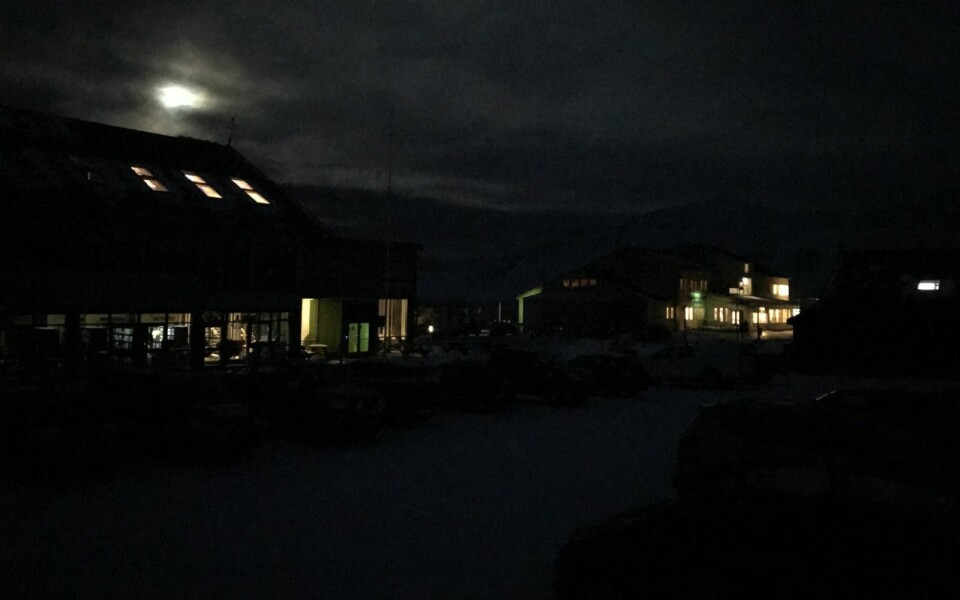 MØRKLAGT: Longyearbyen sykehus´ strøm-backup og månen over et ellers mørklagt Longyearbyen sentrum.