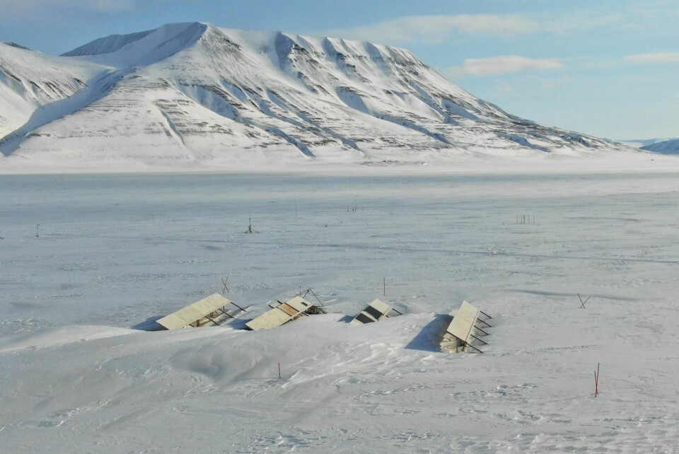 Snøproblem: Dronefoto av anlegget i Adventdalen sent på vinteren. Sesongens strømproduksjon har akkurat begynt, men snøfonnene har vokst seg store nok til å delvis begrave en rad av anlegget.