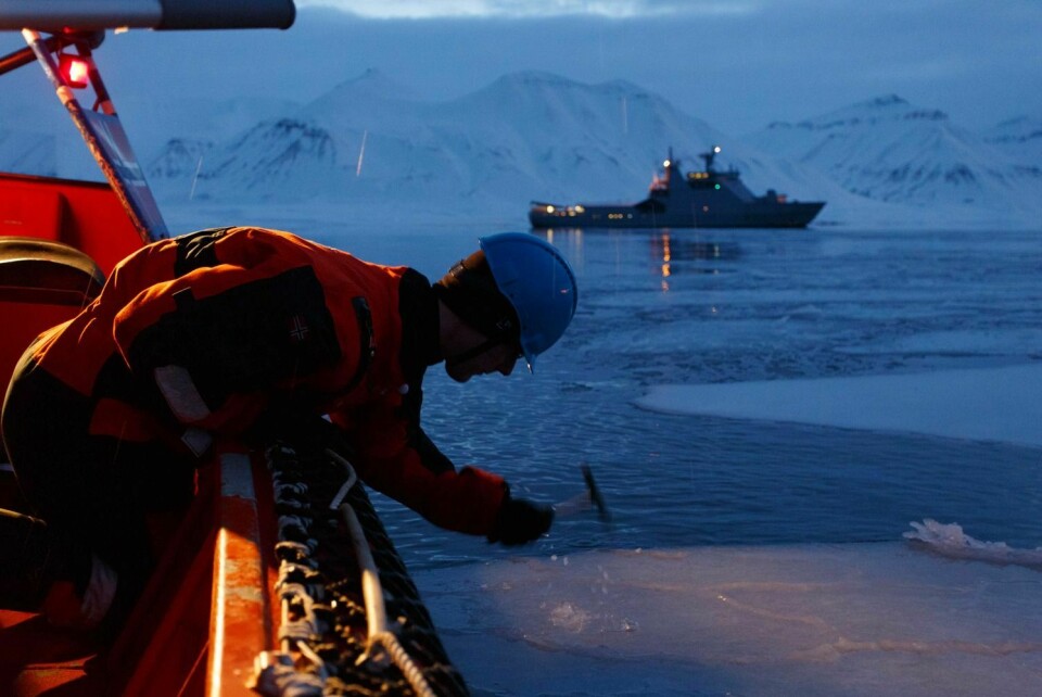 Isprøver blir tatt i Billefjorden, med KV «Svalbard» i bakgrunnen.