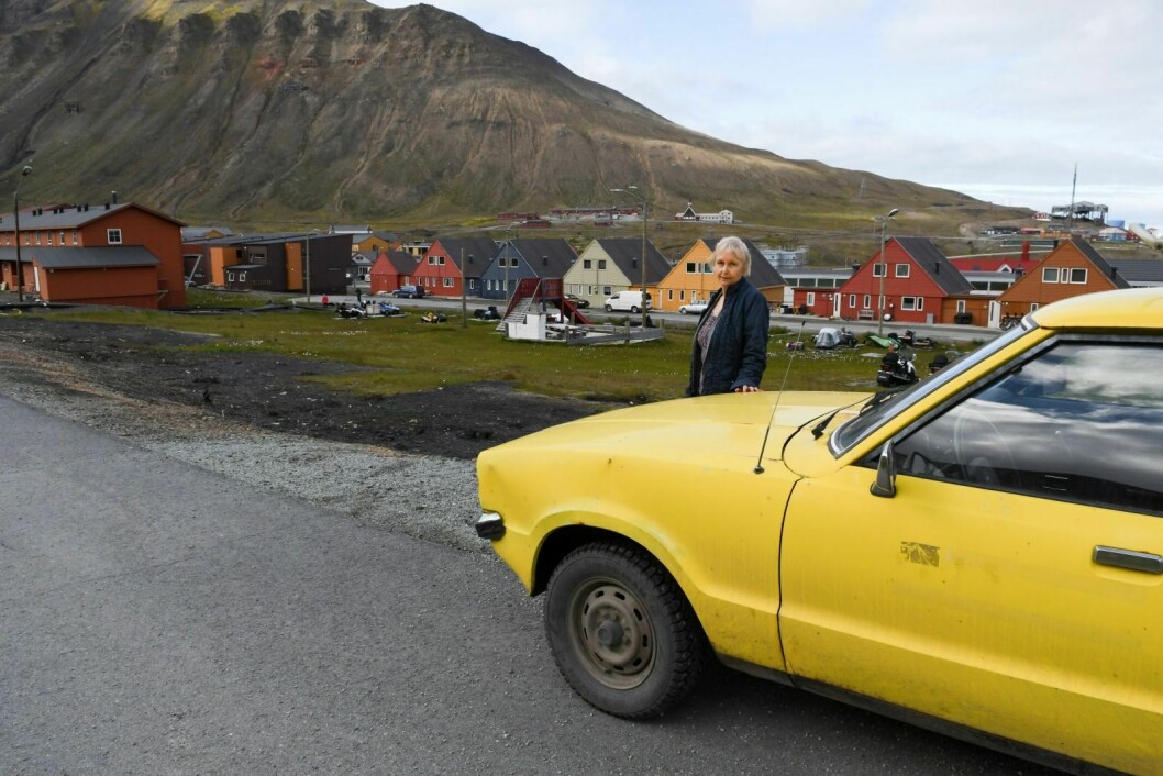 Nora Grøndal har parkert den  gule Forden sin ved tomta der spisshuset deres stod.