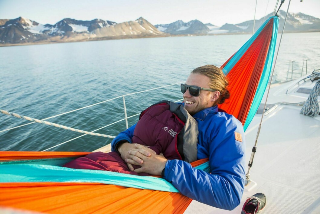 Mats Grimsæth (22) ligger i hengekøya på seilbåten «Humla» utenfor Ny-Ålesund. Til tross for sin unge alder har han denne sommeren vært ekspedisjonsleder på seilas rundt Spitsbergen.