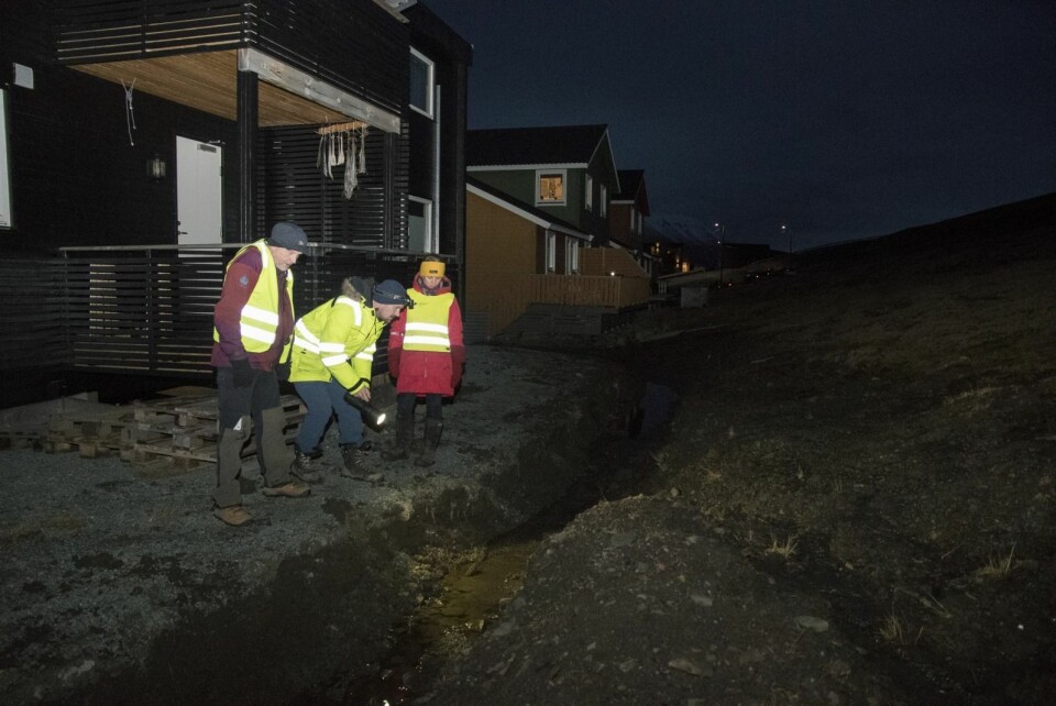 Konstituert sjef Kjersti Olsen Ingerø for teknisk sektor i Longyearbyen lokalstyre var på befaring i terrenget sammen med konstituert teknisk sjef Marius Larsen og professor Ole Humlum ved Unis (nærmest). Her ser de på dreneringsgrøften ved husene.