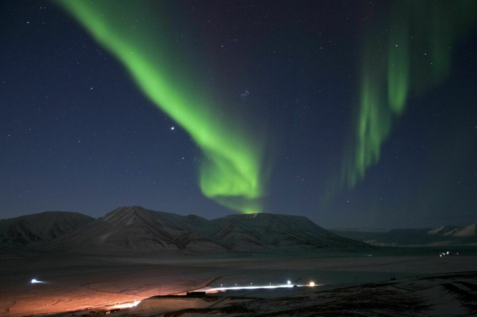 Nordlyset bukter seg over Adventdalen og Operafjellet. Nå begynner turistene for alvor å oppdage den mørke årstiden på Svalbard.