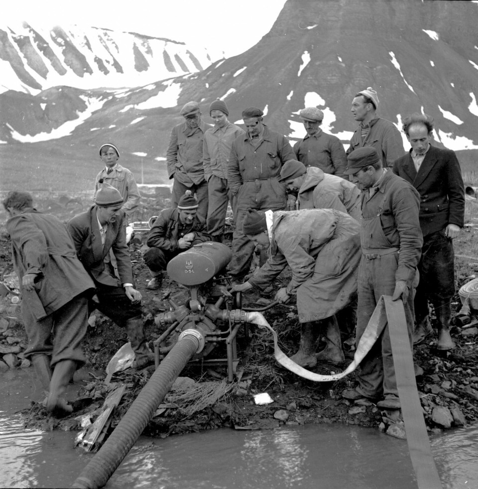 Hva foregår her? Hvor befinner karene seg? Bildet er tatt i 1962.