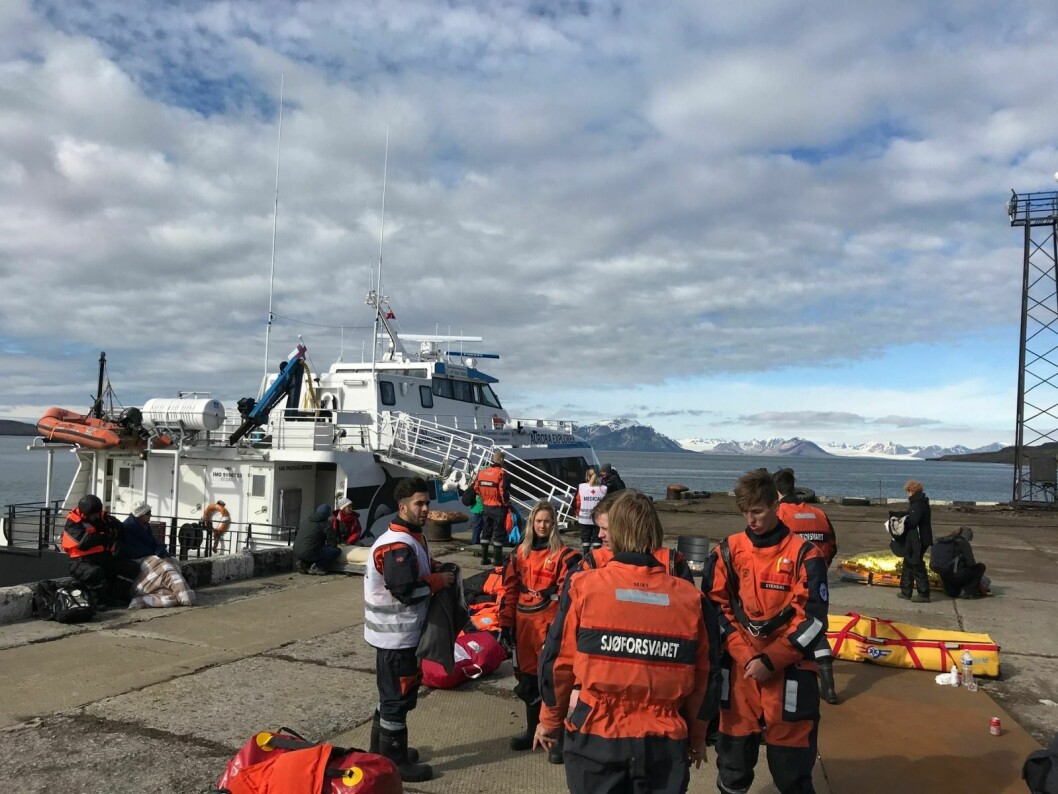 34 personer kom til skade da Aurora Explorer (i bakgrunnen) krasjet med kaia i Barentsburg.
