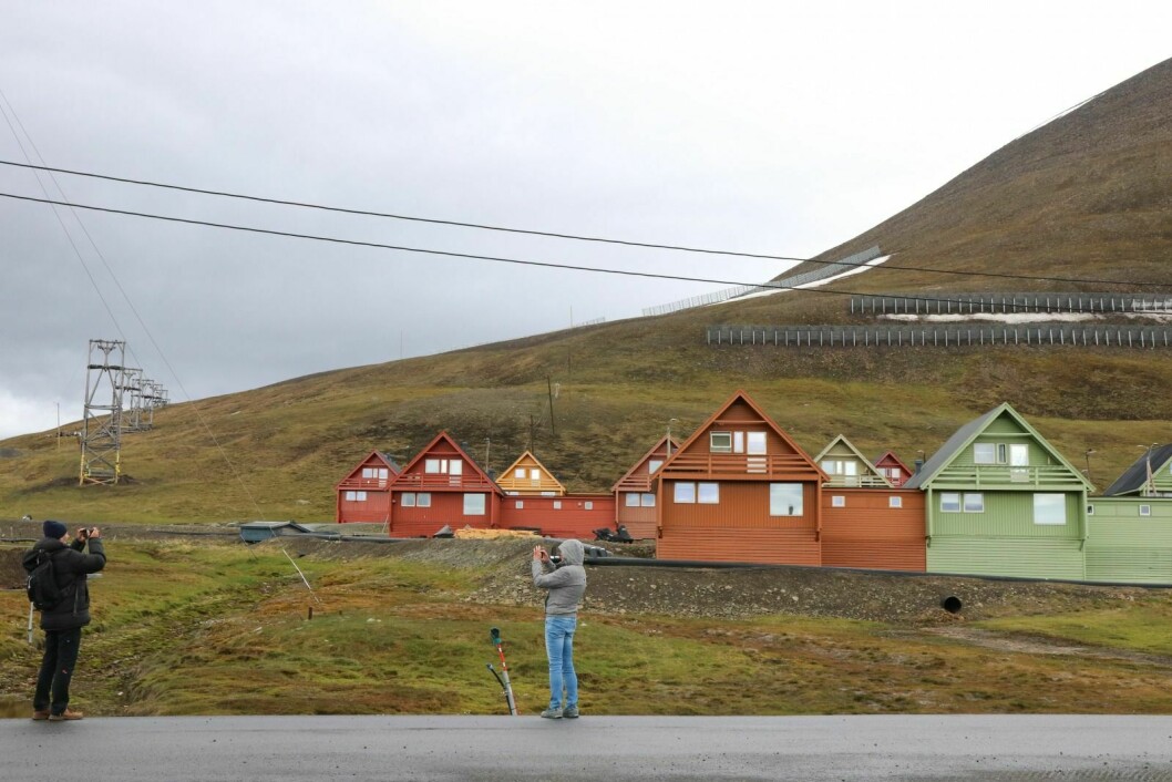 TURISTMÅL: Å ta bilder av spisshusene, som for mange turister er et symbol på Longyearbyen, er noe de vil rekke mens de er på besøk. Det vet også de som bor i husene.