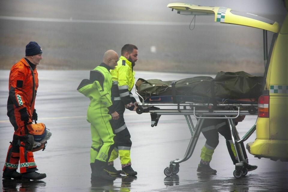 En cruise-ansatt ble skadd i hodet da besetningen gikk i land. Her blir mannen fraktet på båre fra helikopteret og inn i en ventende ambulanse på Svalbard lufthavn.
