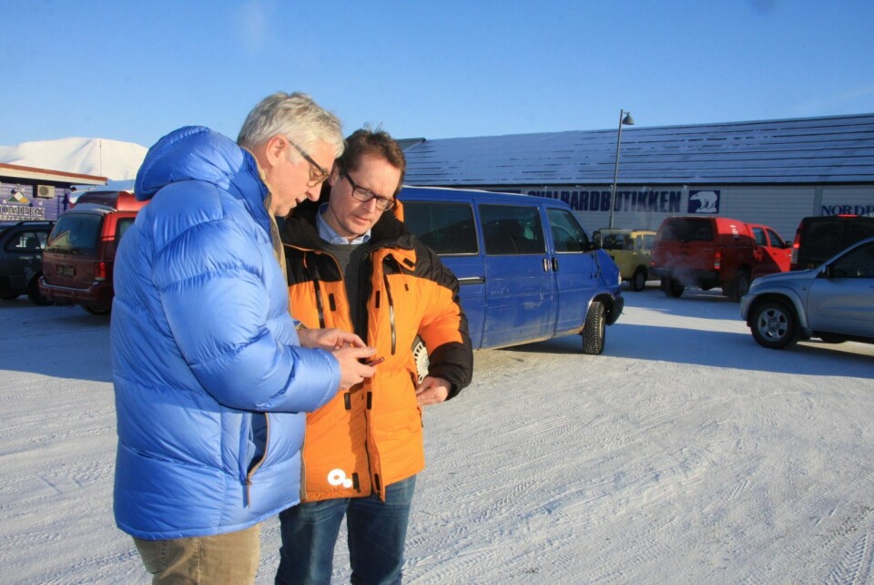 Terje Carlsen og Pål Berg tester mobilappen som skal brukes til å betale parkeringen i Longyearbyen fra sommeren av.