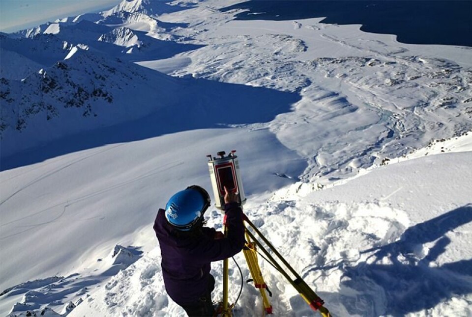 Alexander Prokop, skredforsker ved Unis, bruker en terrestrisk laserskanner for å måle snødybde på Svalbard.