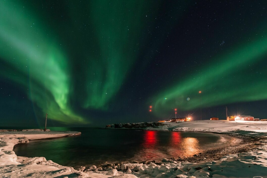 BJØRNØYA: Nordlys over den meteorologiske stasjonen på Bjørnøya. For å fortsatt ha effektiv drift på stasjonen, tester Meteorologisk institutt ut måter å automatisere oppgaver.