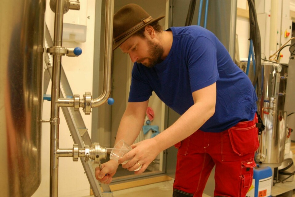 Bryggerimester Andreas Hegermann Riis tapper vann fra sisternen for å sjekke vannkvaliteten.