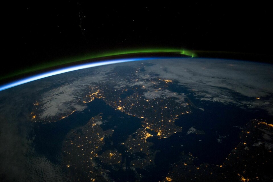 Foto1: Nordlys og månelys ligger som en kappe rundt den nordlige halvkule. Kunstig lys fra byer er tydelig synlig fra NASA sin internasjonale romstasjon.