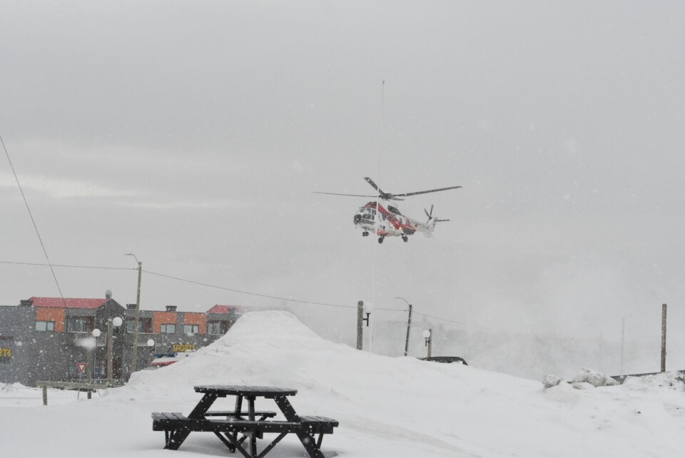 Et helikopter lander like ved Longyearbyen sykehus i tett snødrev. Et helikopter lander like ved Longyearbyen sykehus i tett snødrev.