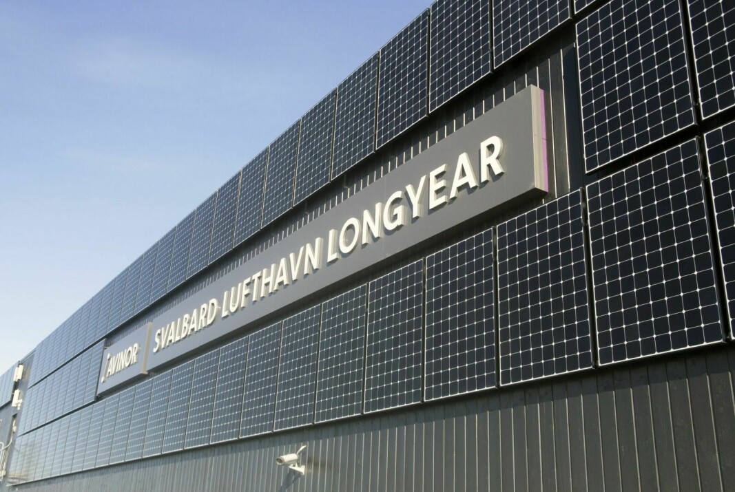 Skiltet på Svalbard Lufthavn Longyear er omringet av solcellepaneler. Disse ble satt opp i 2017.