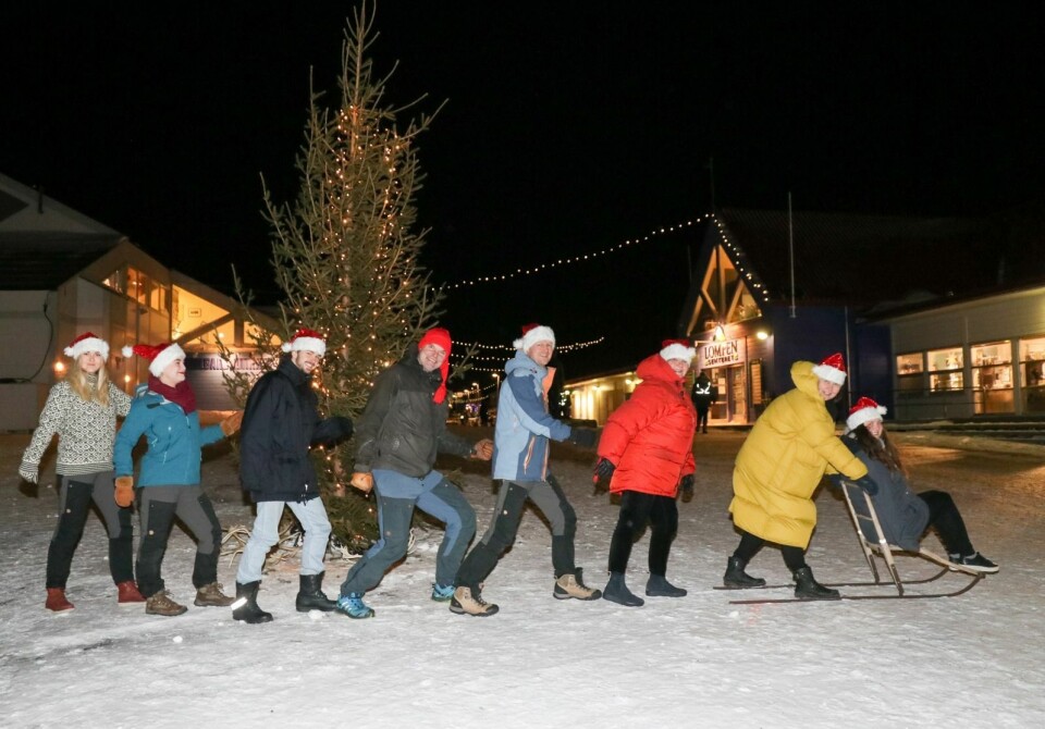 AVISFOLKET: Vi i Svalbardposten ønsker alle leserne våre en riktig god jul og et godt nytt år! Her ser du også hvordan vi ser ut, idet vi legger i vei mot et nytt år over torget i Longyearbyen. Fra venstre går Siri Åbø Wiersen (journalist), Rikke Hoddø Steinbakk (markedskonsulent), Marius Larsen (praktikant), Christopher Engås (journalist), Morten Fredheim Solberg (journalist), Wenche Sørensen (sekretær) og Hilde Røsvik (redaktør) mens Ingrid Ballari Nilssen sitter på sparken.