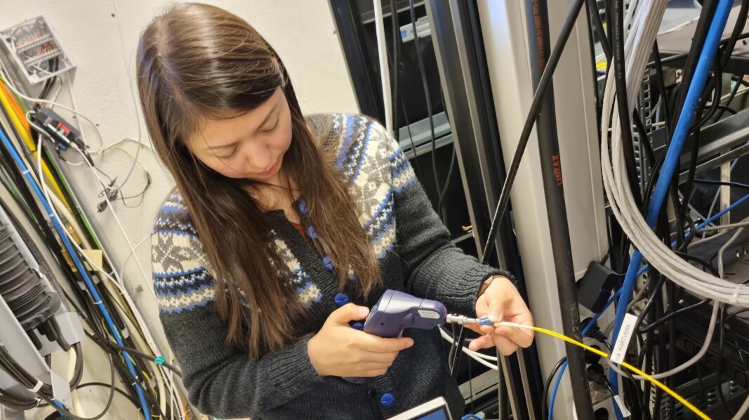 PhD-stipendiat Kristina Skarvang rengjør fiberen som går ut i Kongsfjorden fra Ny-Ålesund.