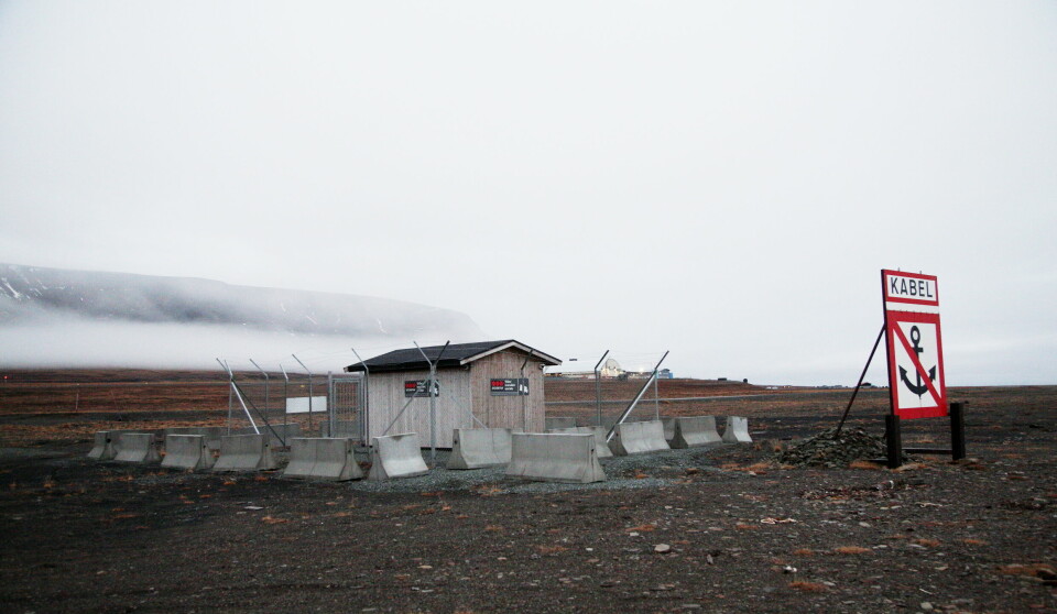 Uthuset hvor fiberkabelen kommer inn ved land i Longyearbyen er sikret med et gjerde og overvåkes.
