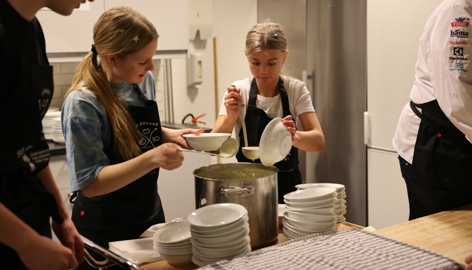 Unge kokker: Lone Johnsen Killi og Pia Ervik i full gang med å fôre sultne ungdomskoleelever med et kulinarisk måltid. Her helles potet- og purreløksuppe i skåler.