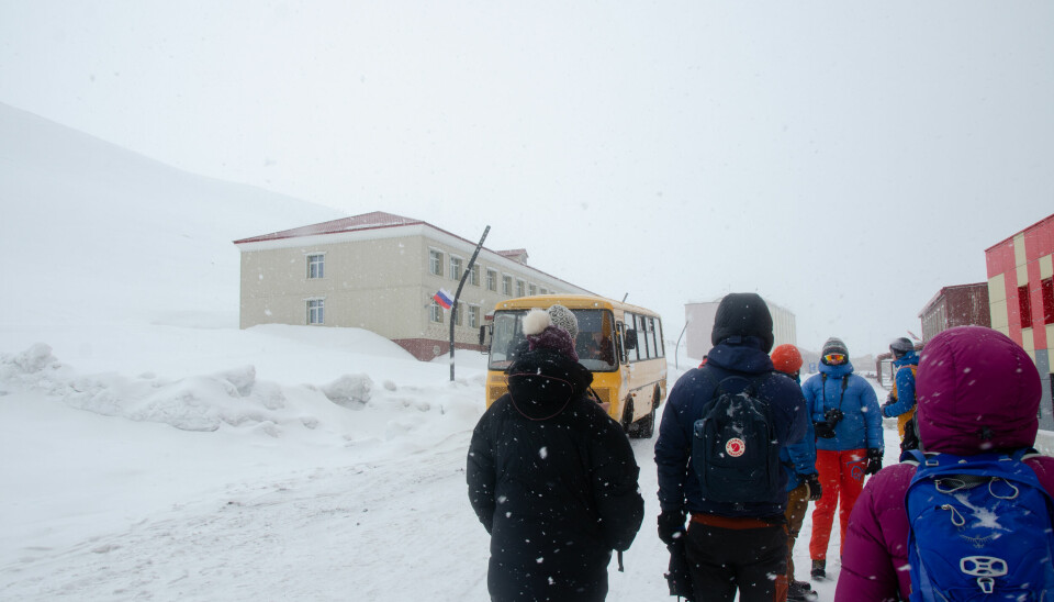 Bussen kjører forbi turistfølge i Barentsburg.