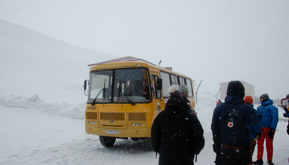 Bussen køyrer forbi turistfølge i Barentsburg våren 2023.