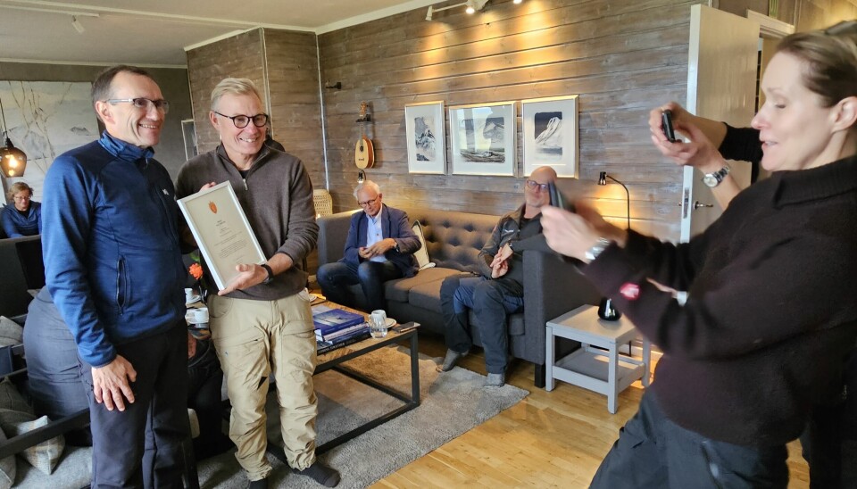 Klima- og miljøminister Espen Barth Eide og administrerende direktør Rune Midtgaard med beviset på at Isfjord radio er fredet. Riksantikvar Hanna Geiran foreviger øyeblikket.