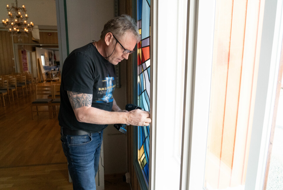 Rune Eriksen monterer opp det nye glassmaleriet i Svalbard kirke.