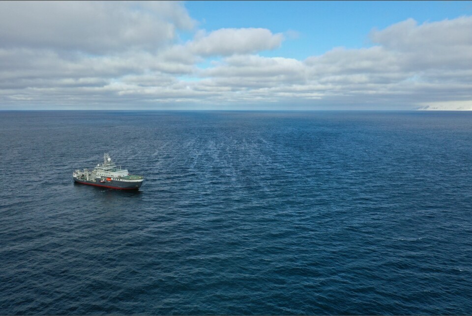 Forskningsskipet Kronprins Haakon liggende midt i et oljeflak utenfor Prins Karls Forland. Oljeflaket ser du som lyse, skimrende striper midt i bildet.