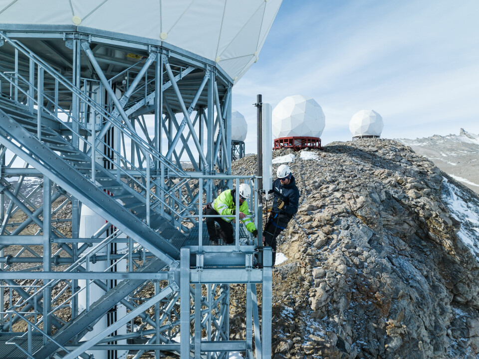 Her jobber Einar Jenssen (t.h.) og Vegard Evjen fra Telenor Svalbard med å montere opp antenna som sikrer mobildekning på Troll.